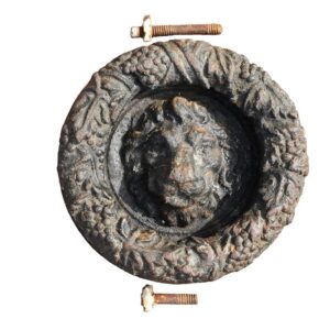 An antique cast iron lion head and garland door knocker showing weathering and detailed design.