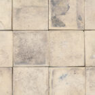 Reclaimed traditional buff Norfolf pamment tiles showing an authentic weathered face and remnants of mortar and lino flooring