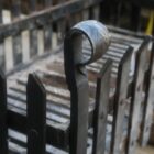 Reclaimed cast iron fence style fire basket detail showing the shepherds crook motif on the corner finial