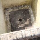 a small composite stone planter, showing the drainage hole in the base