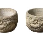 A pair of reclaimed composite stone planters with Norman style carving and a fine patina.