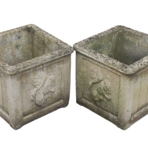 A pair of composite stone planters with a playful squirrel motif that shows the aged patina of years spent exposed to the elements