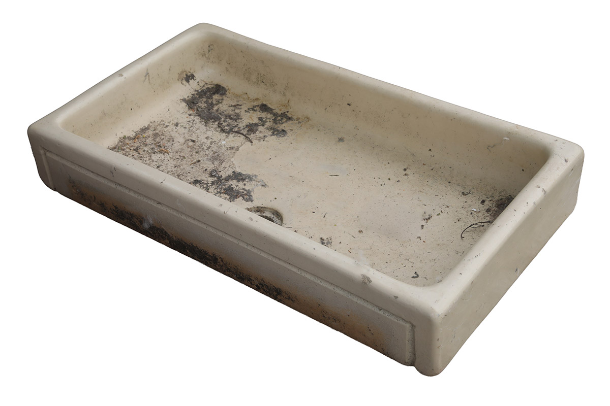 A shallow Butler sink with cream glaze and the weathered patina of age, use and reclamation