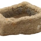 A reclaimed Northamptonshire sandstone trough showing a heavily weathered surface and hand carved chisel marks.