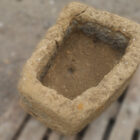 A reclaimed hand carved Northamptonshire sandstone trough showing the highly weathered surfaces and drainage hole