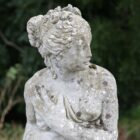 A reclaimed statue of Pandora with a fine weathered patina of lichen and moss