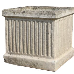 A reclaimed Willowstone composite stone planter with classical fluted sides and a weathered patina