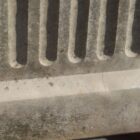 A close up detail shot of a reclaimed Willowstone composite stone planter with classical fluted sides and weathered patina