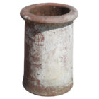A reclaimed red roll top chimney pot showing discolouration and a historic coat of white paint on one side.