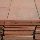 A stack of red reclaimed Ruabon quarry tiles showing the 15mm thickness and mild weathering across the surfaces