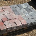 Red and black quarry tiles ready for installation in a classic chequerboard, four square or diamond pattern