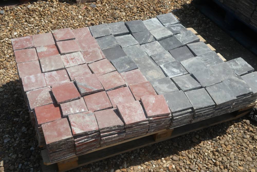 Red and black quarry tiles ready for installation in a classic chequerboard, four square or diamond pattern