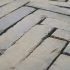 close up of reclaimed Victorian Staffordshire Blue Pavers laid out in a classic herringbone pattern, showing worn edges and surface 2 RPAV-0141