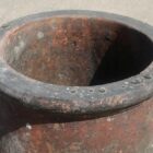 A well weathered rim of a red roll top chimney pot.