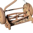 Detail of an antique push mower from the early 1900's, named The Trojan, showing heavy surface weathering
