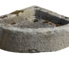 A rustic, hand carved antique Yorkstone corner sink with a rich patina of environmental discolouration, surface wear and patches of lichen and moss