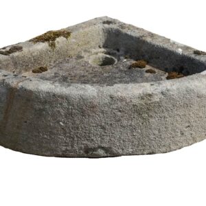 A rustic, hand carved antique Yorkstone corner sink with a rich patina of environmental discolouration, surface wear and patches of lichen and moss