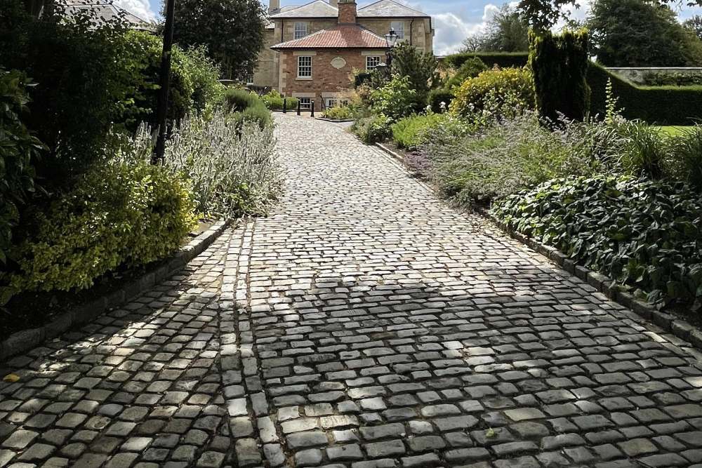 Landscaped path of reclaimed cobbles and path edgings, sourced and supplied by Watling Reclamation