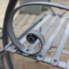 Detail of this bistro set of table and 2 chairs, the elegant scroll work arm rest. The set is hot zinc dipped for durability and will develop a fine patina over time.