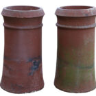A pair of reclaimed terracotta chimney pots with a cannon top design and consistent weathering.