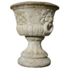 One of a pair of lions head urns in composite stone stone, showing a fine patina of weathered surfaces and spots of lichen.