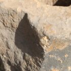 Detail of damaged reclaimed hand-carved sandstone millstone with a rich natural patina. Ideal for garden seating, plinths, or water features.