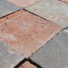 Time worn 6" red and blue quarry tiles showing a weathered surface and worn edges