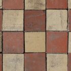 A batch of reclaimed red and buff quarry tiles showing an aged patina of surface wear and discolouration that brings a depth of character