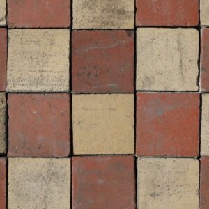 A batch of reclaimed red and buff quarry tiles showing an aged patina of surface wear and discolouration that brings a depth of character
