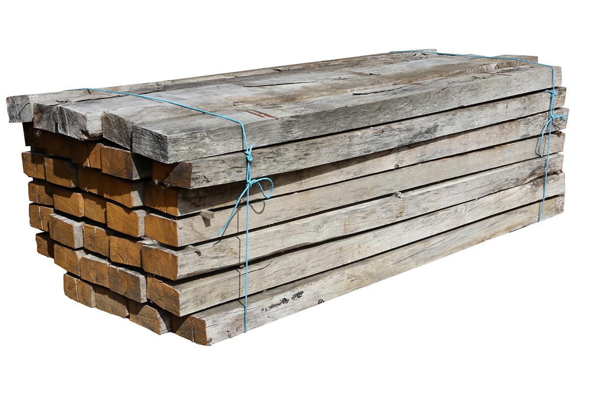 A large batch of seasoned but unused oak sleepers with a silvered patina that helps them blend into established garden designs