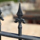 a section of spear top railings with concave design joining two different size sections
