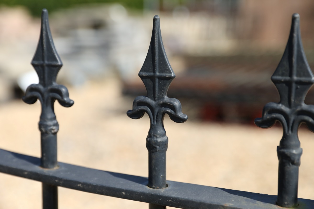 a section of spear top railings with concave design joining two different size sections