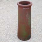 A reclaimed tall red roll top chimney pot with weathered patina
