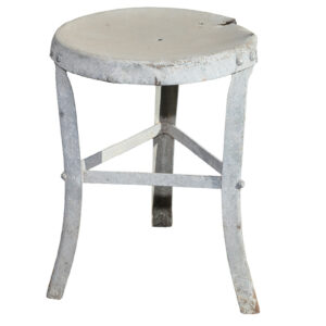 A reclaimed galvanised milking stool with weathered surfaces and heavy wear to the seat.