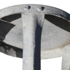 A reclaimed galvanised milking stool with weathered surfaces and heavy wear to the seat.