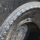 Detail of a reclaimed cast iron bedroom fireplace insert with a decorative arch design.
