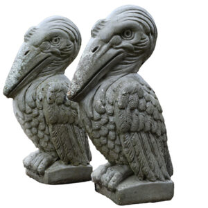 Lightly weathered composite stone pelican statues with a stylised look and solid visual presence