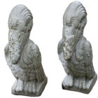Lightly weathered composite stone pelican statues with a stylised look and solid visual presence
