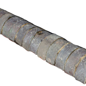 A run of reclaimed Staffordshire blue half round wall copings showing remnants of mortar and a weathered patina