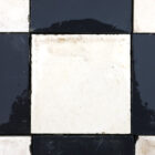 A detail of the batch of reclaimed commercial kitchen flooring made up of 10cm square ceramic tiles and showing the classic chequerboard pattern