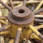 Detail of a hub and spokes on reclaimed iron wagon wheels with a fabulous weathered patina of peeling paint and surface corrosion
