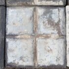 Close detail of a rare reclaimed square blue stable paver showing a heavily weathered patina of worn faces and environmental discolouration