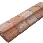 A batch of reclaimed flat top red brick Bishops Hat wall copings with a light patina