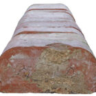 Detail of a run of reclaimed red double bullnose bricks showing the remnants of mortar from previous use.