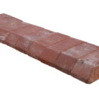 New old stock of red plinth header bricks showing the slight aged patina of time in storage