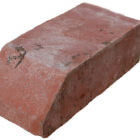 Detail of new old stock red plinth header bricks showing the slight aged patina of time in storage