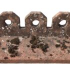 A single ridge tile from a batch of Redland concrete crested ridge tiles showing the heavy weathering of lichen and moss