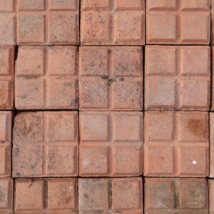Rare, reclaimed square red stable pavers showing weathered surfaces and worn edges