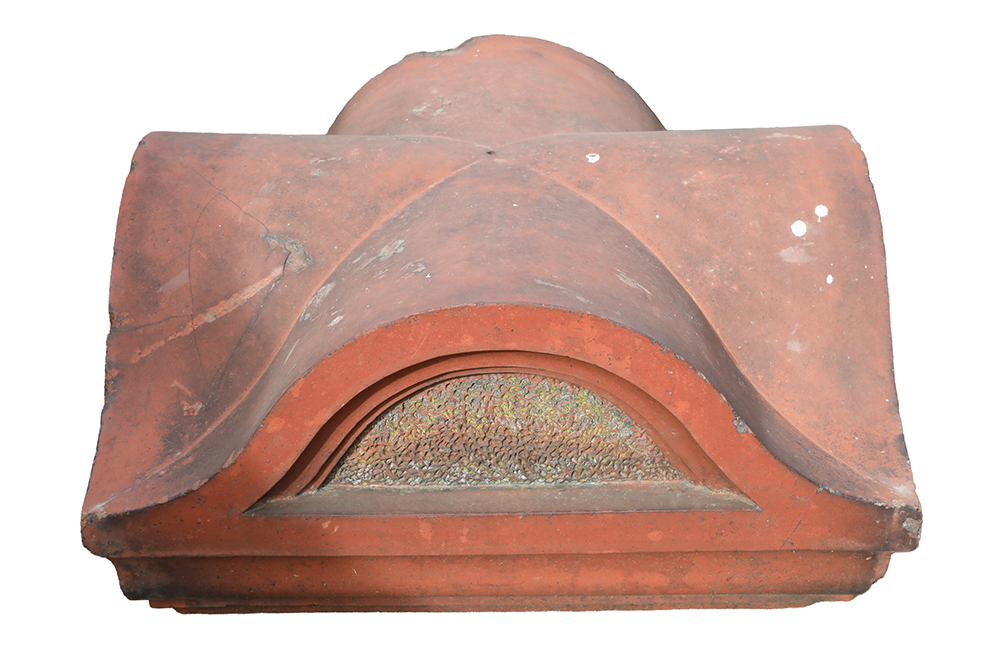 A profile image of one of a pair of well weathered Victorian terracotta pier caps, showing a fabulous patina of lichen and organic discolouration.