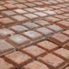 A detail of a batch of uncommon, weathered red stable pavers showing a fine patina of surface wear and discolouration